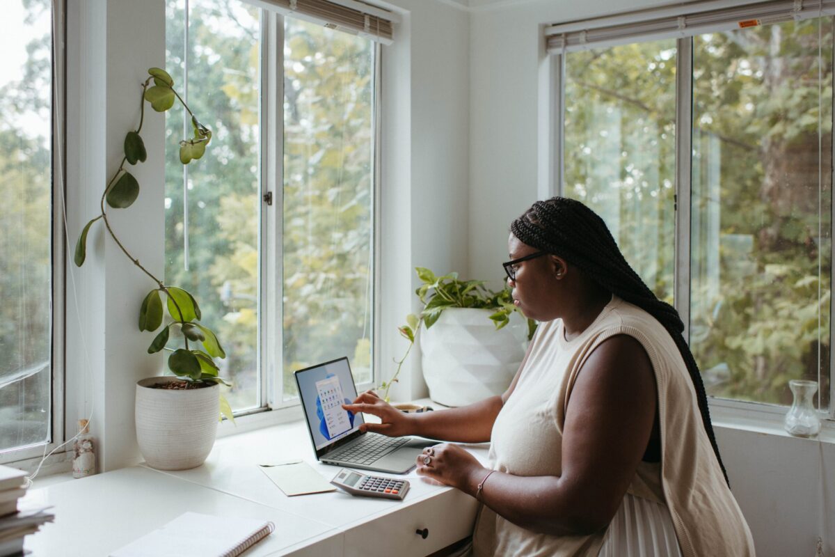 Person Working on a Laptop in Front of a Window